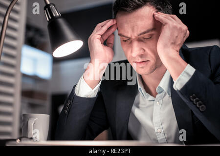 Smart nice tired man touching his temples Stock Photo