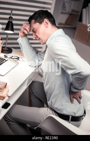 Depressed unhappy man suffering from pain in the back Stock Photo