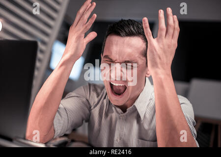 Sad cheerless man feeling stressed out from work Stock Photo