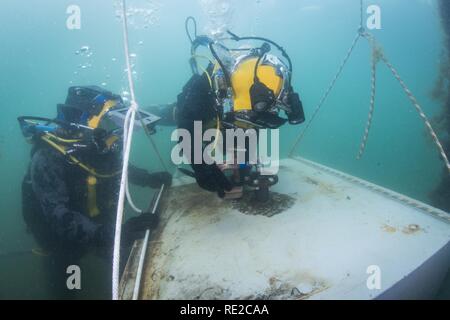 Petty Officer 3rd Class Sean Black, assigned to Mobile Diving Salvage Unit (MDSU) 1, and a Royal Australian Navy Diver, prepare for an underwater welding exercise during Exercise Dugong 2016, in Sydney, Australia, Nov. 9, 2016. Dugong is a bi-lateral U.S Navy and Royal Australian Navy training exercise, advancing tactical level U.S. service component integration, capacity, and interoperability with Australian Clearance Diving Team (AUSCDT) ONE. Stock Photo