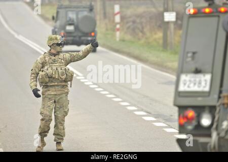 U.S. Army 1st Lt. Alexander G. Canacci, Paratrooper, Company D, 2nd Battalion, 503rd Infantry Regiment, 173rd Airborne Brigade, directs traffic during a Polish Independence Day parade involving his unit, Canadian soldiers assigned to 1st Battalion, Princess Patricia Canadian Light Infantry, and Polish soldiers (not pictured) throughout the township of Drawsko Pomorskie, Poland, Nov. 11, 2016. The Troops helped their Polish counterparts celebrate the country's national holiday that commemorates the anniversary of the restoration of Poland's sovereignty as the Second Polish Republic in 1918. Stock Photo