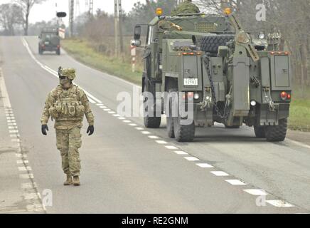 U.S. Army 1st Lt. Alexander G. Canacci, Paratrooper, Company D, 2nd Battalion, 503rd Infantry Regiment, 173rd Airborne Brigade, directs traffic during a Polish Independence Day parade involving his unit, Canadian soldiers assigned to 1st Battalion, Princess Patricia Canadian Light Infantry, and Polish soldiers (not pictured) throughout the township of Drawsko Pomorskie, Poland, Nov. 11, 2016. The Troops helped their Polish counterparts celebrate the country's national holiday that commemorates the anniversary of the restoration of Poland's sovereignty as the Second Polish Republic in 1918. Stock Photo