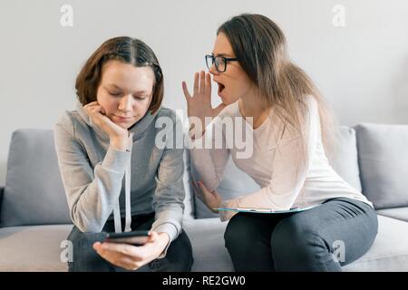 Young woman professional psychotherapist talking with teen girl in office. Mental health of child in adolescence. Stock Photo