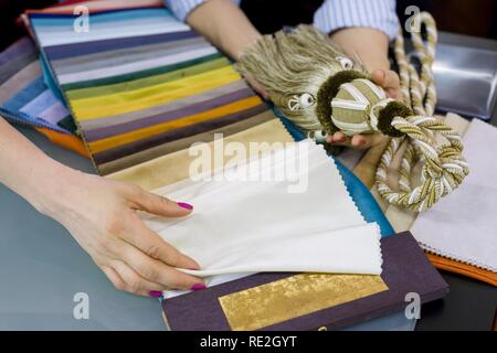 Women watch samples of fabrics for curtains, furniture upholstery in a new house Stock Photo