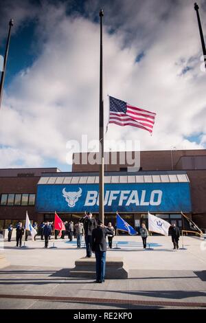 The American flag is raised and then lowered to half-staff at 11:11 A.M. to mark the end of World War I as was traditionally celebrated by Armistice Day, during the opening of Veterans Day ceremonies at the University at Buffalo, Amherst, N.Y., Nov. 11, 2016. The State University of New York at Buffalo held a Veterans Day event to remember the service and sacrifice of all veterans over the course of the nation's history. Stock Photo