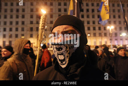 Kiev, Ukraine. 19th Jan 2019. A protester seen wearing a face mask during the demonstration while other holding torches. Ukrainian activists of different nationalists movements seen taking part at a rally to demand the investigation of the killings of the Maidan activists during Euromaidan or Revolution of Dignity 2014. The protest is timed to the anniversary of the escalation of the confrontation during Euromaidan on January 19, 2014. Credit: SOPA Images Limited/Alamy Live News