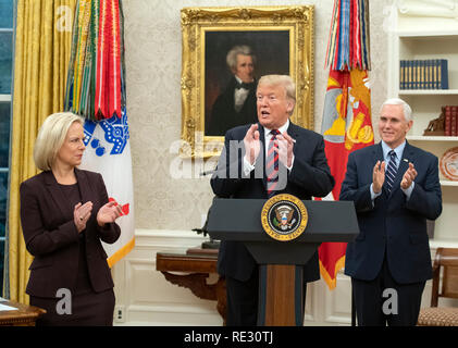 United States President Donald J. Trump applauds the new US citizens as he hosts a naturalization ceremony in the Oval Office of the White House in Washington, DC on Saturday, January 19, 2019. At left is US Secretary of Homeland Security (DHS) Kirstjen Nielsen and at right is US Vice President Mike Pence. Credit: Ron Sachs/Pool via CNP | usage worldwide Stock Photo