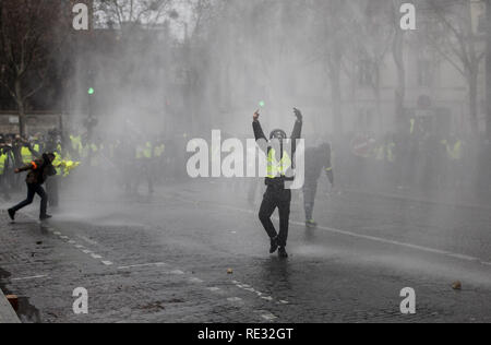 Paris, France. . 19th Jan, 2019. Protestor reacts to the Police water cannon during a demonstration against French President Macron policies. Yellow vest protestors gathered and marched on the streets of Paris another Saturday on what they call the Act X against French president Emmanuel Macron's policies. Credit: Bruno Thevenin/SOPA Images/ZUMA Wire/Alamy Live News