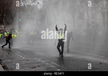 Paris, France. 19th Jan 2019. Protestor reacts to the Police water cannon during a demonstration against French President Macron policies. Yellow vest protestors gathered and marched on the streets of Paris another Saturday on what they call the Act X against French president Emmanuel Macron's policies. Credit: SOPA Images Limited/Alamy Live News