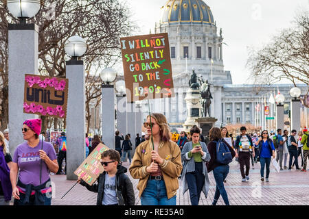 San Francisco, USA. 19th Jan 2019.  Participants to the Women's March event hold signs with various messages; the City Hall building visible in the background Stock Photo