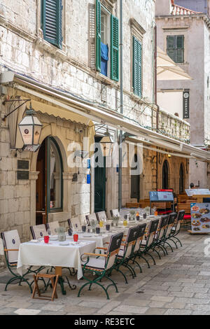 Dubrovnik, Croatia - April 2018 : Customer tables set up and ready for food service outside one of popular restaurants in Dubrovnik Old Town Stock Photo