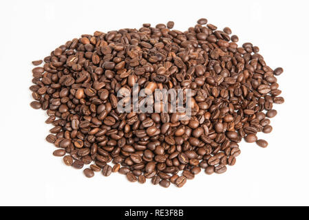 A big mound of dark roasted and dried arabica coffee beans set on a plain white background. Stock Photo