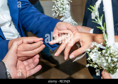 Traditional wedding ceremony in orthodox church, golden wedding rings exchange. Close up. Stock Photo