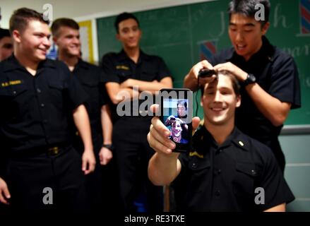 ANNAPOLIS, Md. (Nov. 17, 2016) Midshipman 1st Class Christian Scroggs videos himself as his head is shaved during a service assignment ceremony in Bancroft Hall. At this annual event, midshipmen learn which warfare community they will join after graduation, in May. Stock Photo