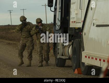 (From left) Senior Airman Dustin Silc and Staff Sgt. Tyler Chronister, 791st Missile Security Forces Squadron convoy response force members, perform a perimeter sweep of a payload transporter during a recapture and recovery exercise at the missile complex, N.D., Nov. 16, 2016. During the simulated scenario, defenders recovered an asset that was taken over by hostile forces. Stock Photo