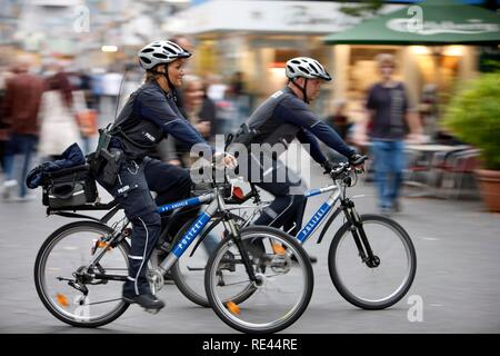 Bike police patrolling in a pedestrian zone Stock Photo