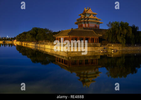 Beijing / China - October 10th 2018: Northwestern tower of the Forbidden City reflecting in the water moat during still night.
