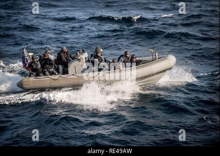 SEA OF JAPAN (Nov. 17, 2016) Sailors assigned to the forward-deployed Arleigh Burke-class guided-missile destroyer USS Barry (DDG 52) visit, board, search and seizure (VBSS) team approach the ship in a rigid-hull inflatable boat (RHIB) during a training exercise. Barry is on patrol in the U.S. 7th Fleet area of operations supporting security and stability in the Indo-Asia-Pacific region. Stock Photo