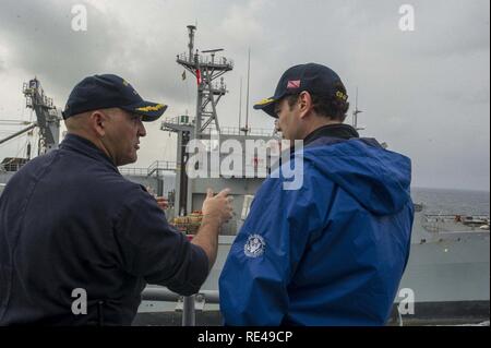 ARABIAN GULF (Nov. 25, 2016) Commanding Officer Capt. Dennis Valez, left, describes how and underway replenishment works to Congressman Jason Chaffetz aboard the guided-missile cruiser USS San Jacinto (CG 56). San Jacinto, deployed as part of the Eisenhower Carrier Strike Group, is supporting maritime security operations and theater security cooperation efforts in the U.S. 5th Fleet area of operations. Stock Photo