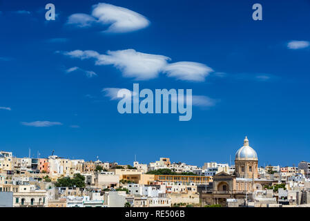 Cityscape view of Kalkara, Malta with blue sky and interesting clouds and St. Joseph Church Stock Photo