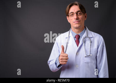 Mature handsome Italian man doctor giving thumb up Stock Photo