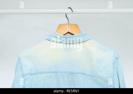 Worn out, bleached out old classic business shirt hanging in a wardrobe Stock Photo