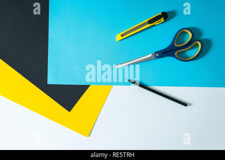 Abstract color paper and colorful papers background with pen, scissors and paper knife on top. Sheets of colored paper for drawing and school. White s Stock Photo
