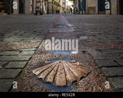 Sun-lit pilgrim's scallop as a trail marker of the Way of Saint James in the old town of Burgos, Castile, Spain Stock Photo