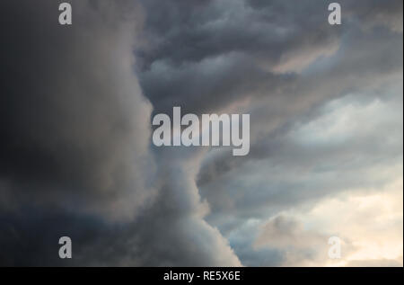 Dark and stormy clouds at sunset Stock Photo