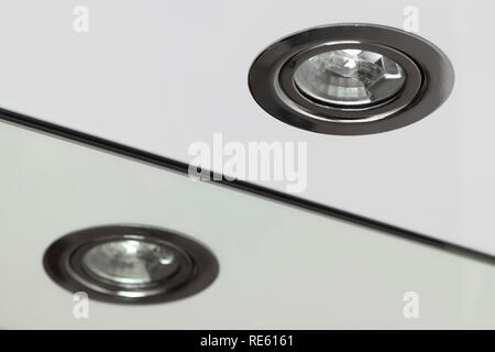 Recessed halogen lamp and reflection in the washbasin mirror. Stock Photo