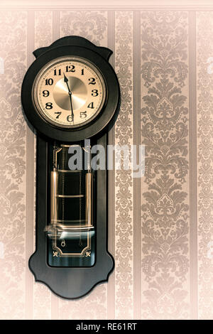 Wall pendulum clock with the fight in the old style. Stock Photo
