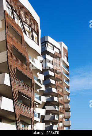 Timber cladding detail on modern apartment blocks with irregular warped angles on the building against a blue sky Stock Photo