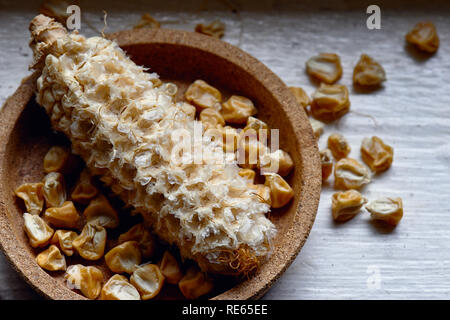 Dried sweet corn seed off the cob in a cork bowl ready for planting. Stock Photo