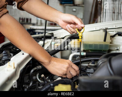 Technician hand opening the car oil tank lid for checking, repair or changing new oil in garage at car auto service for maintenance lubrication engine Stock Photo