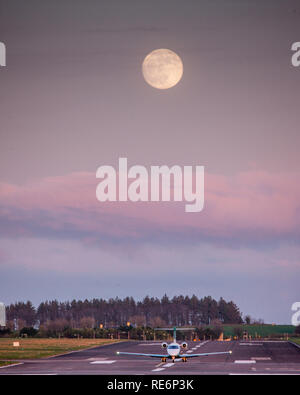 Cork, Ireland. 20th January, 2019. A private jet taxiis on to runway 16/34 prior to take off from Cork  while a full super wolf moon rises at Cork Airport, Cork, Ireland. Credit: David Creedon/Alamy Live News Stock Photo