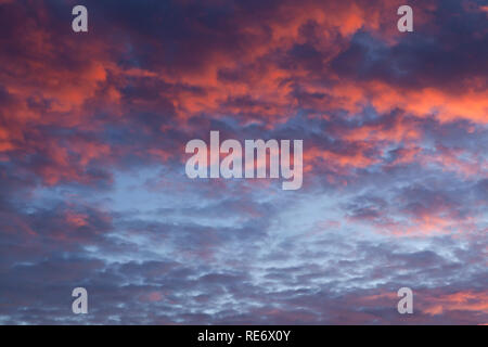Dramatic pink sunset cloudscape with a little blue sky poking through Stock Photo