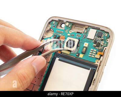 Close-up of technician hand clamping rear camera inside broken disassembled smartphone Stock Photo