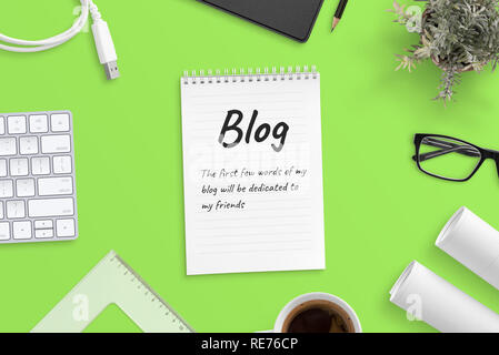 Blog post text on notepad surrounded with office supplies. Green background, top view, hero, header image. Stock Photo