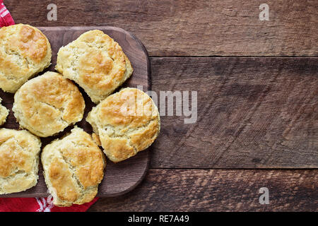 Fresh buttermilk southern biscuits or scones over a rustic wooden table shot from above. Top view. Stock Photo