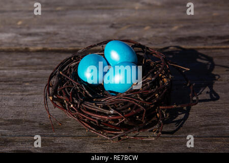 Colorful Easter eggs in the nest on wooden background Stock Photo