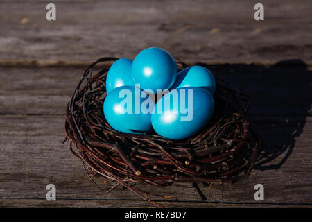 Colorful Easter eggs in the nest on wooden background Stock Photo