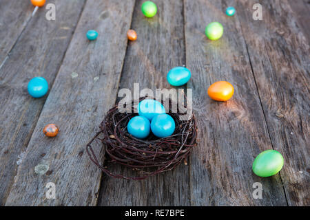 Colorful Easter eggs in the nest on wooden background Stock Photo