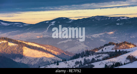 winter sunrise in mountains. beautiful carpathian wonderland. countryside with snow covered rolling hills. good morning wonderful nature Stock Photo