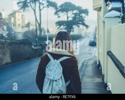 A young woman is standing on the pavement in winter Stock Photo