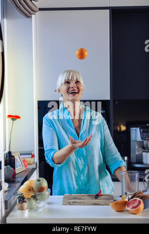 Joyful happy woman playing with an orange Stock Photo