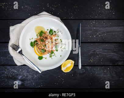 Tartare of salmon served on white plate. Stock Photo