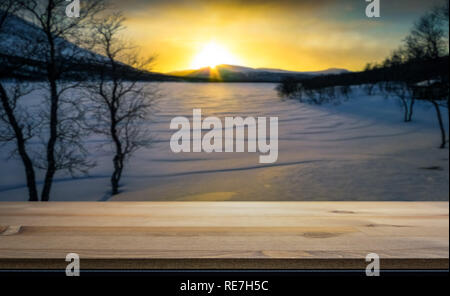 Empty table top for product display montage. Frozen, snowy lake in the sunset blurred in the background. Stock Photo