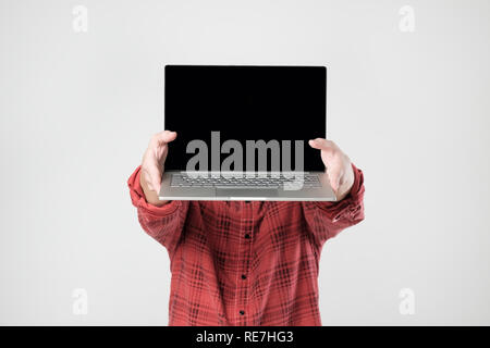 man carrying laptop and showing screen of it standing hiding his face. Stock Photo