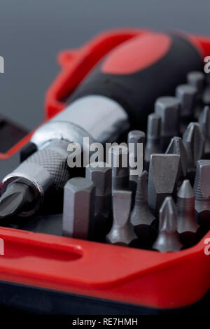 Screwdriver with phillips head in a case with various sized bit set on a black background Stock Photo