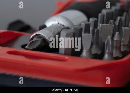 Screwdriver with phillips head in a case with various sized bit set on a black background Stock Photo